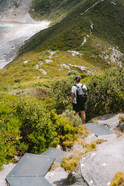 A man walking down a trail with a backpack