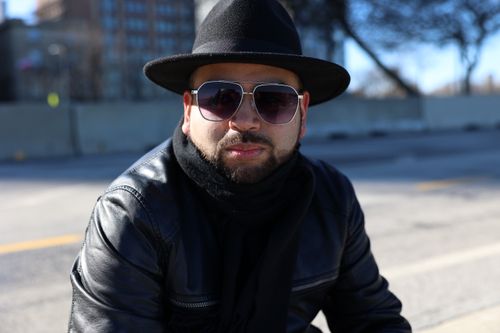 Free Fashionable man wearing sunglasses and hat poses in city street - edgy style portrait. Stock Photo