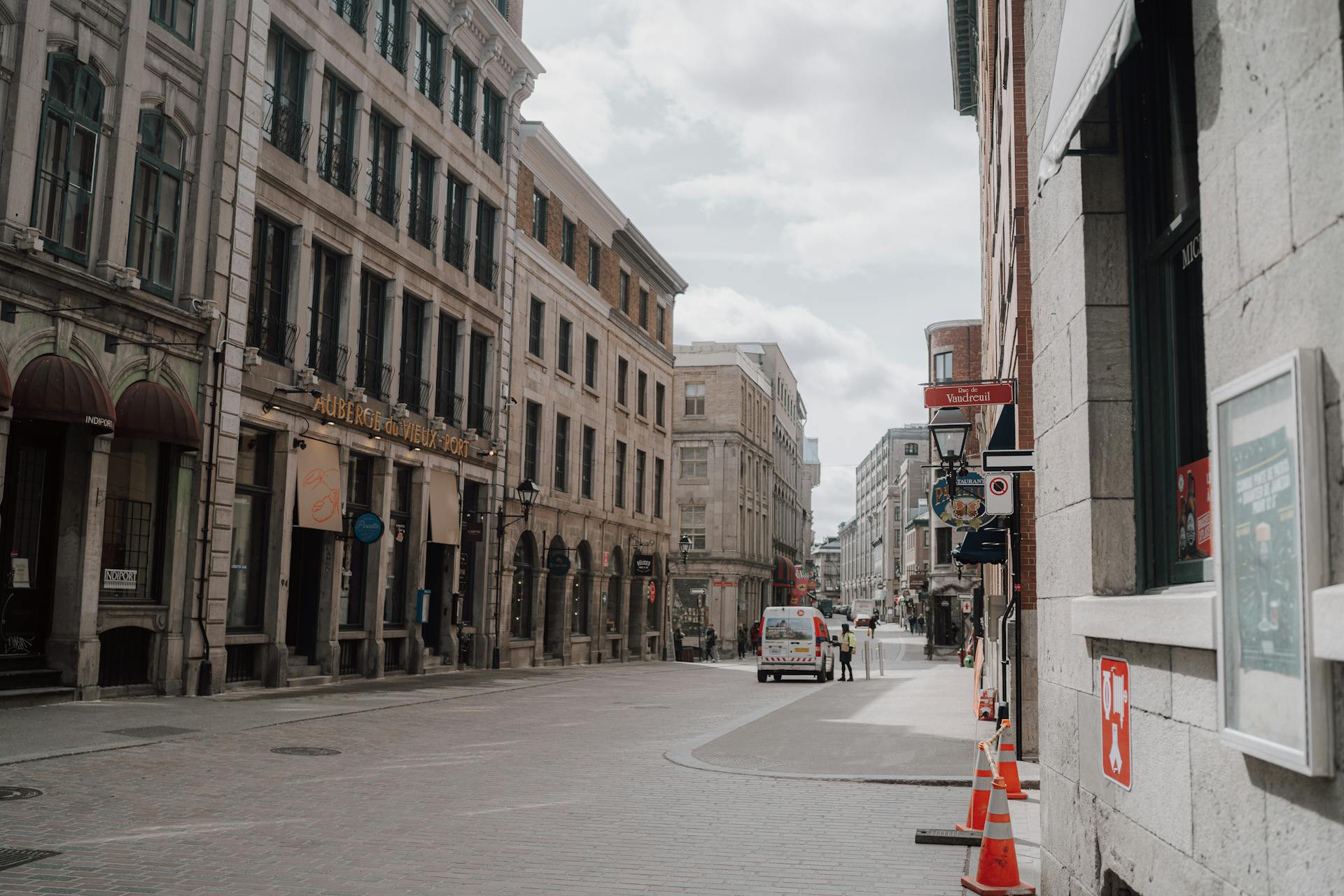 A peaceful street scene in historic Old Montreal with classic architecture under a cloudy sky.