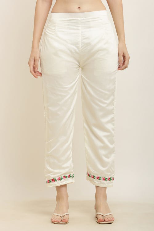 White cotton pants with embroidered floral design
