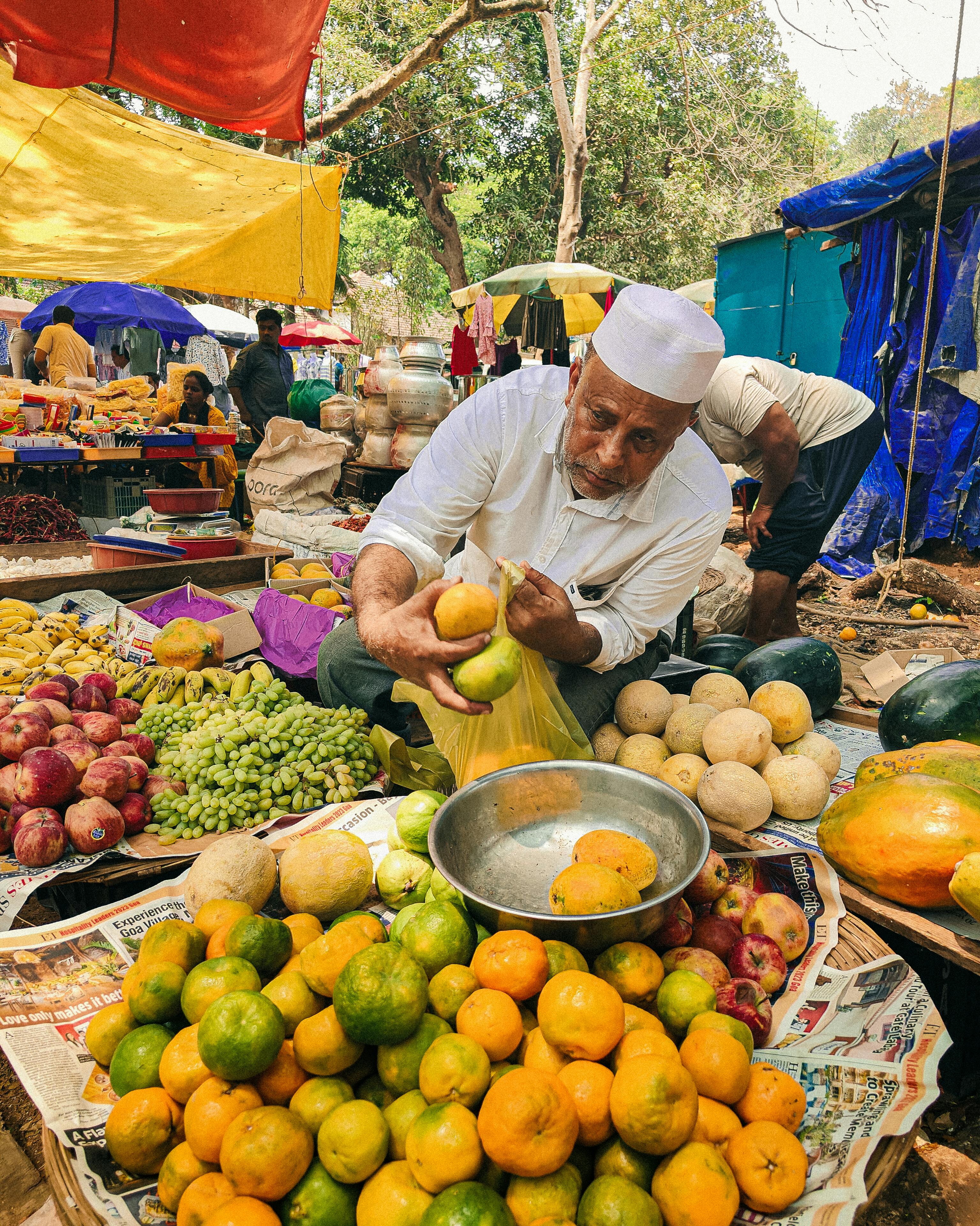 A Man Packing Fruit into a Plastic Bag at a Bazaar