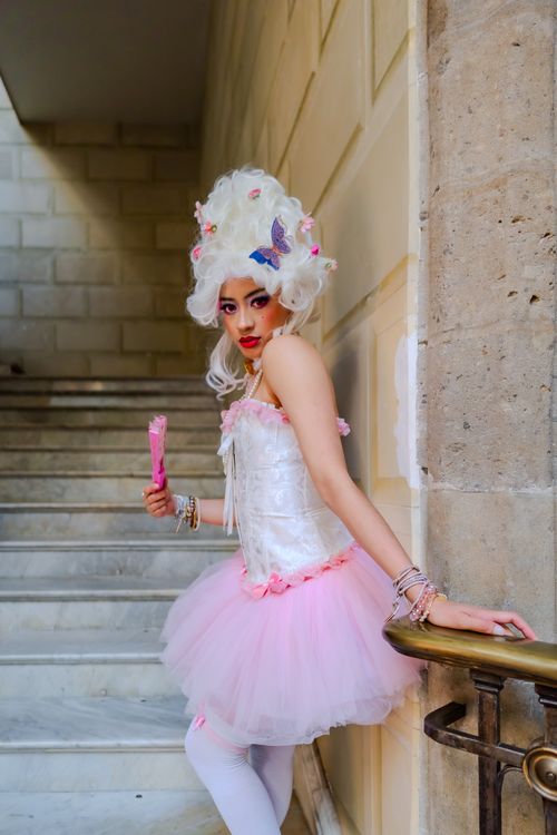 Free A woman poses elegantly in a Marie Antoinette-inspired costume with a pink tutu, indoors. Stock Photo