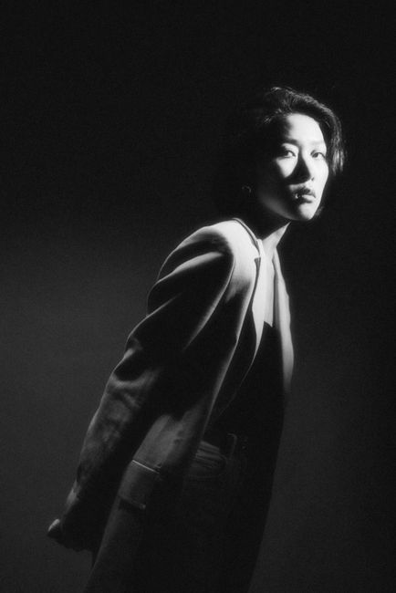 Dramatic black and white portrait of a woman in a studio setting.