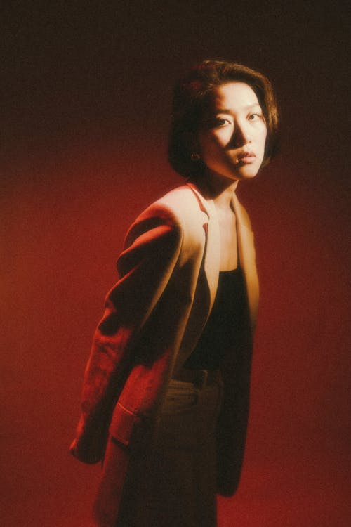 Fotos de stock gratuitas de chaqueta beige, fondo rojo, mujer bonita