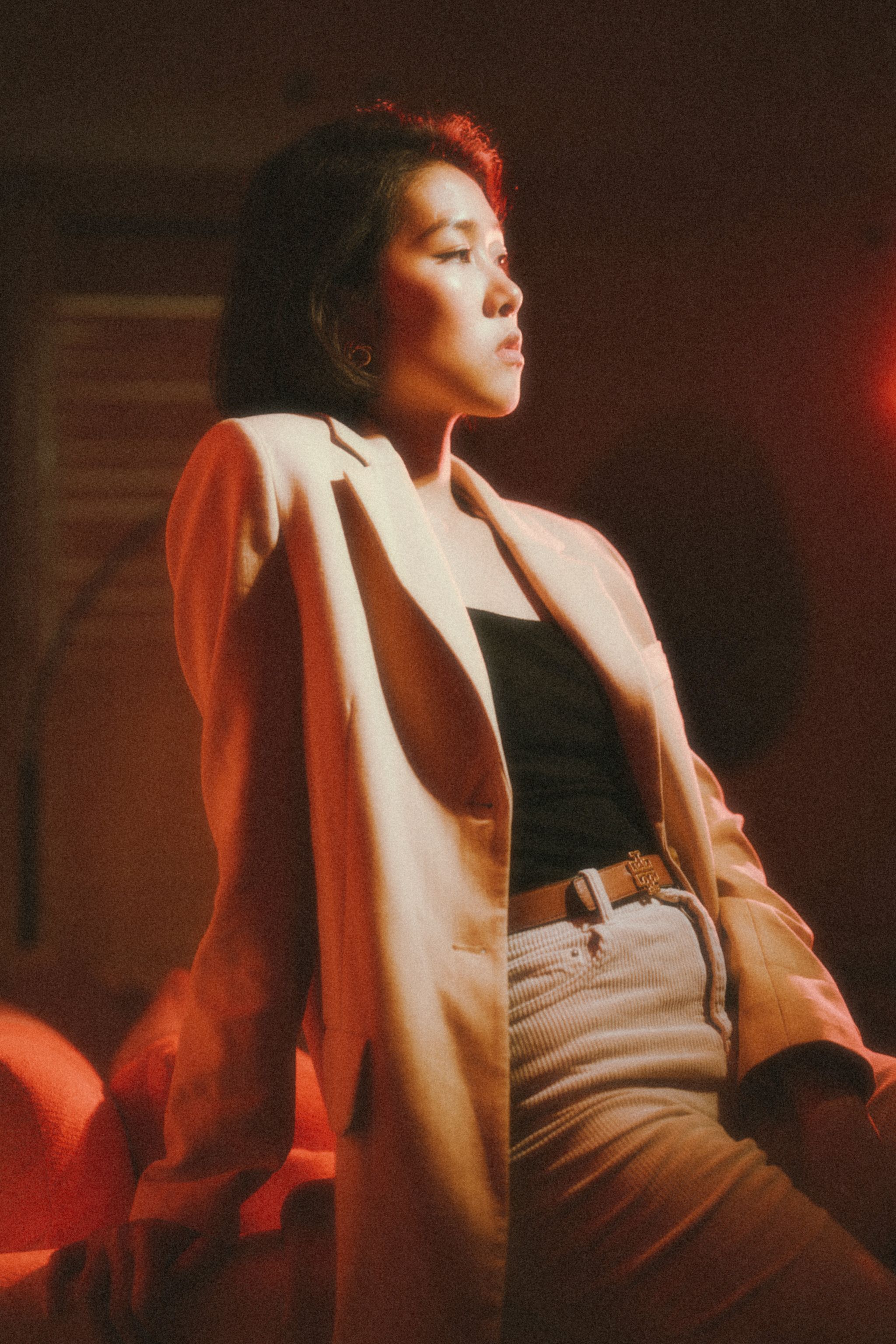 Editorial portrait of a woman in warm, soft light, composed with quiet confidence