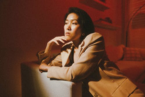 A woman in a tan suit sitting on a couch