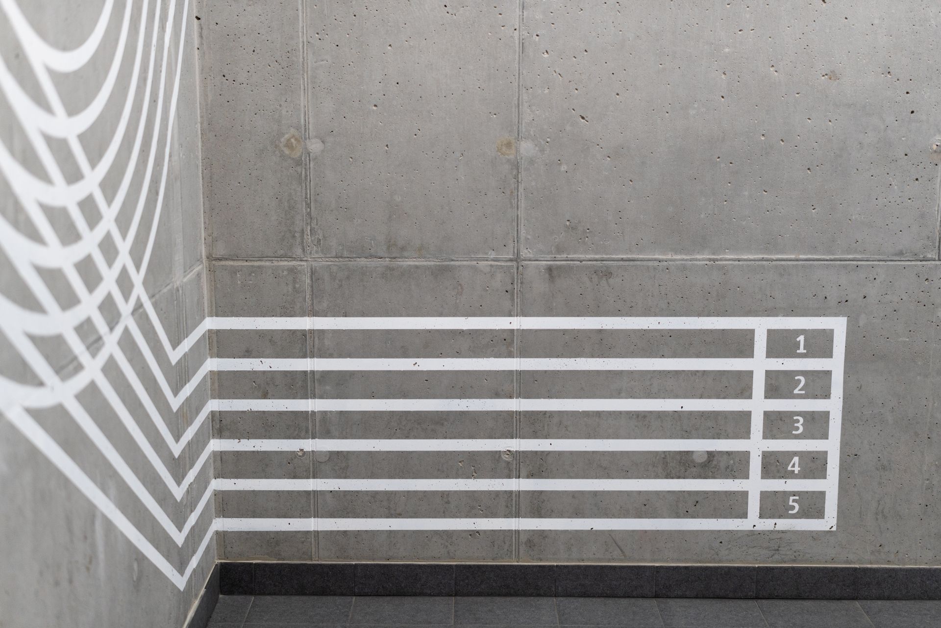 Concrete wall with abstract track lines and numbered sections, ideal for sports-themed backgrounds.