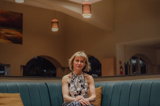 A fashionable woman sitting on a sofa in a stylish café.
