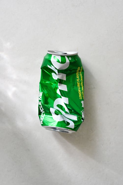 A can of green soda on a white surface