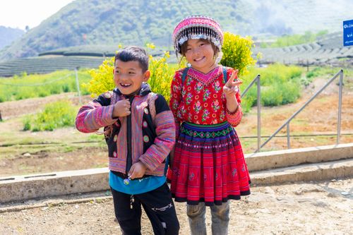 Free Cheerful siblings in colorful traditional clothing enjoying a sunny day in Sơn La, Vietnam. Stock Photo