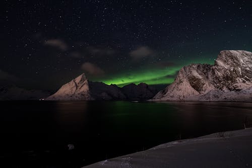 The aurora bore lights up the sky over the mountains