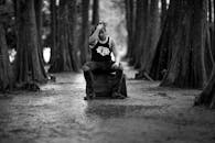 一名男子坐在森林里，拍摄时尚的黑白肖像照片
