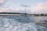 现代吊桥横跨平静的水面，天空充满活力