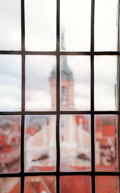 A window with a view of a church and tower