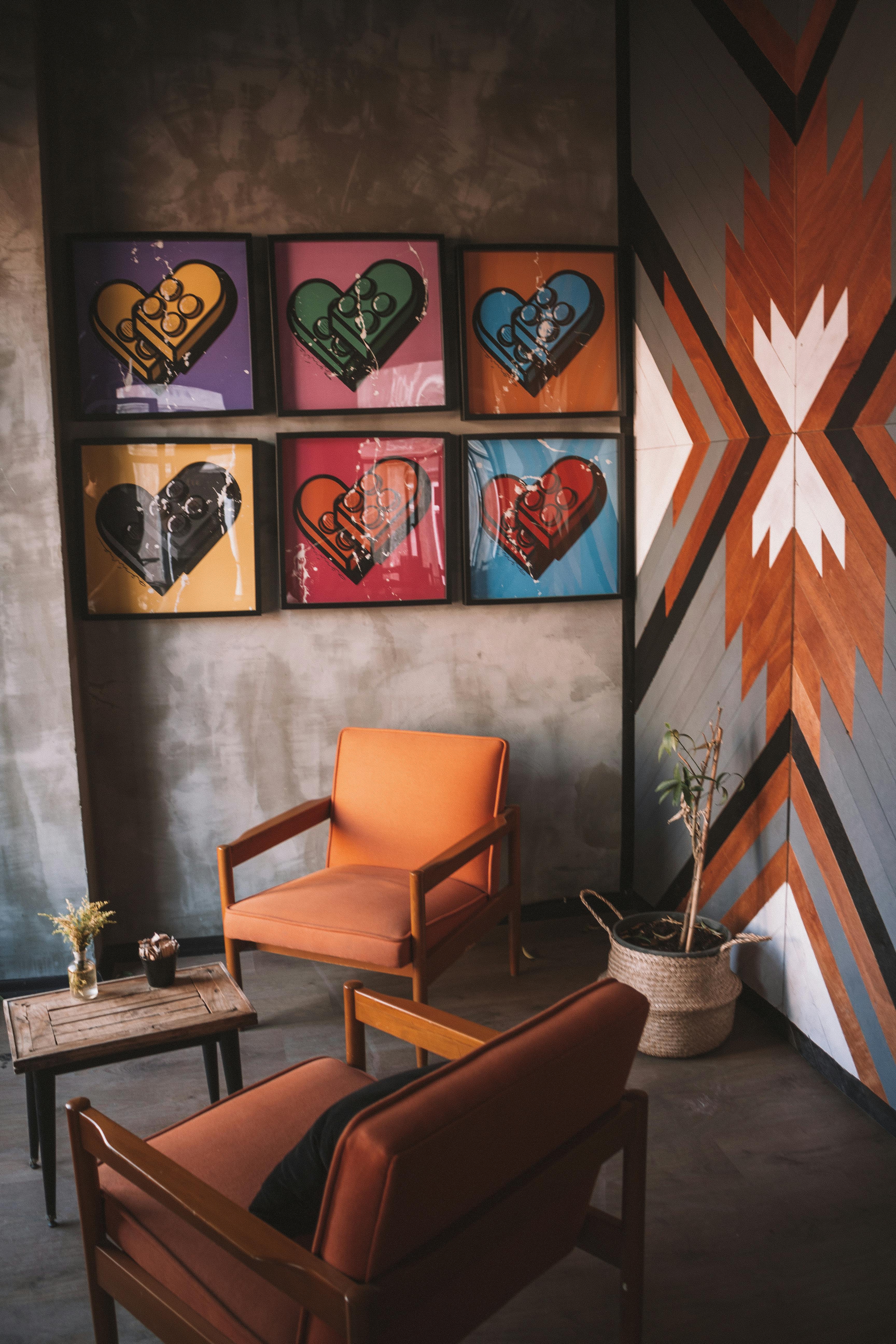 two orange armchairs and assorted color heart wall decors