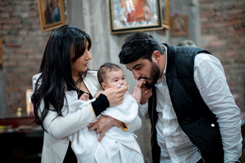 A man and woman holding a baby in a church