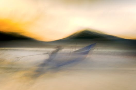Abstract seascape with blurred motion of a fishing boat at sunrise, capturing serene ambient nature.