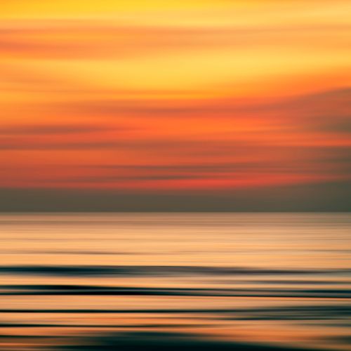 Free A vibrant abstract seascape showcasing warm sunset colors over a calm ocean. Stock Photo