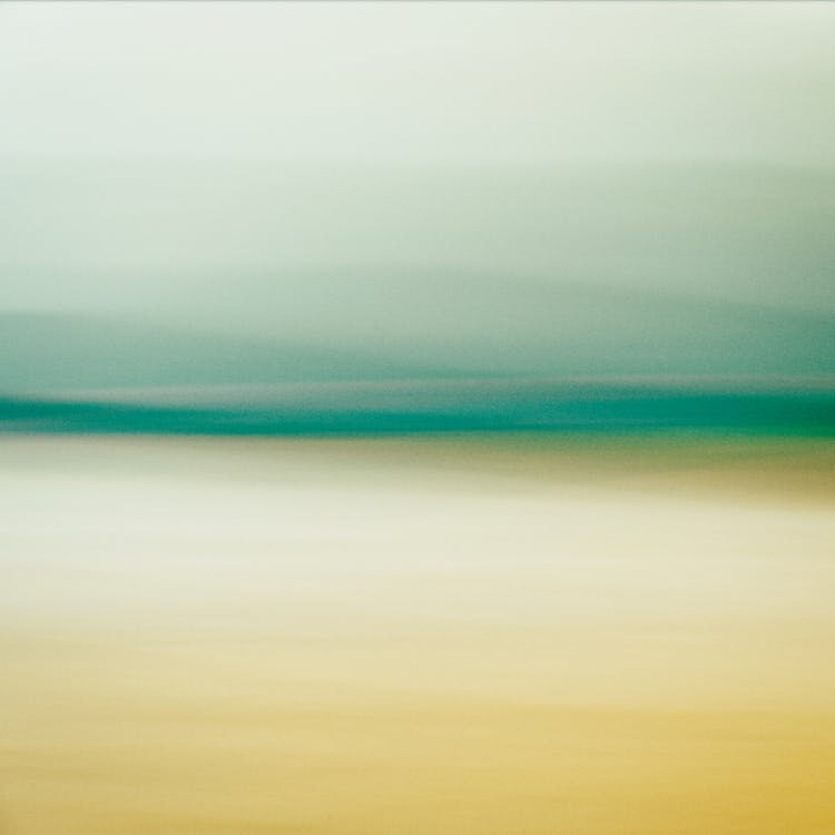 A blurry photograph of a beach with green and yellow