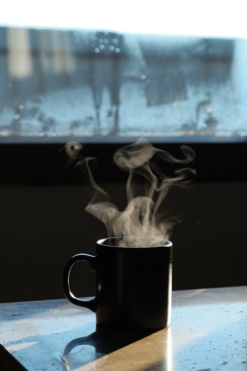 A black coffee cup with steam coming out of it