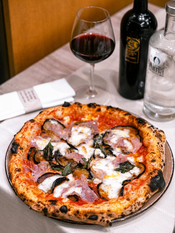 A pizza with meat and vegetables on a plate