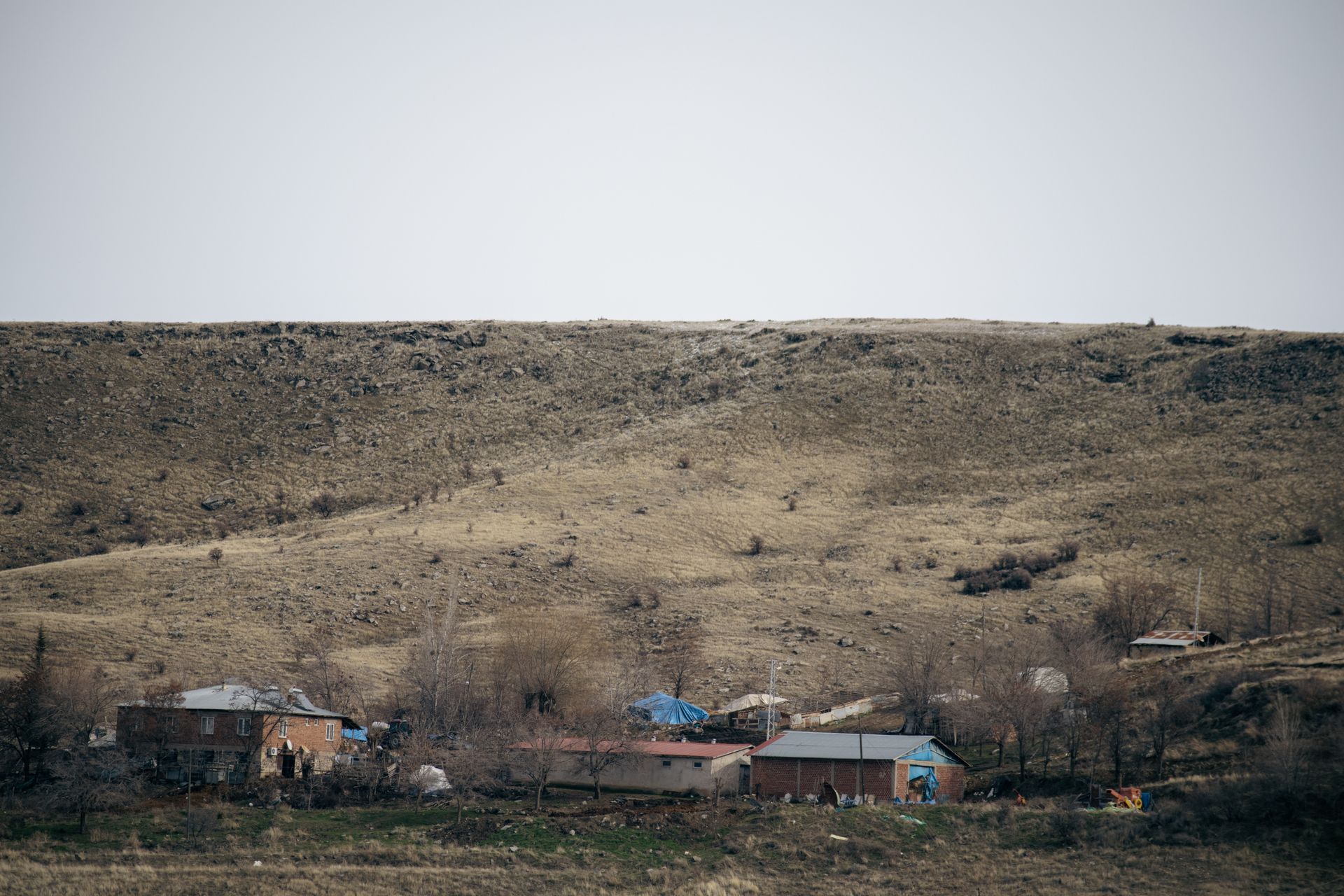 Tranquil rural scene depicting houses at the base of a hill in Elazığ, Türkiye.