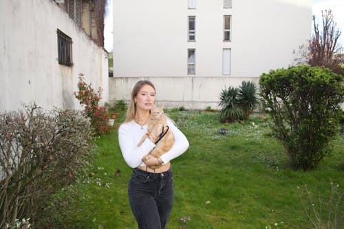 A woman holding a cat in her arms in a garden