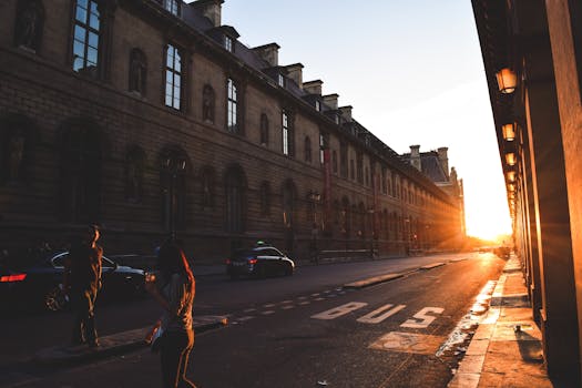 A bustling urban street with historic buildings at sunset, capturing motion and light.