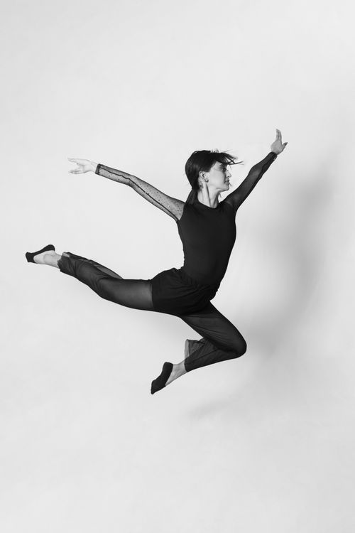 Free A dancer elegantly leaps in a black and white studio setting, capturing motion and grace. Stock Photo