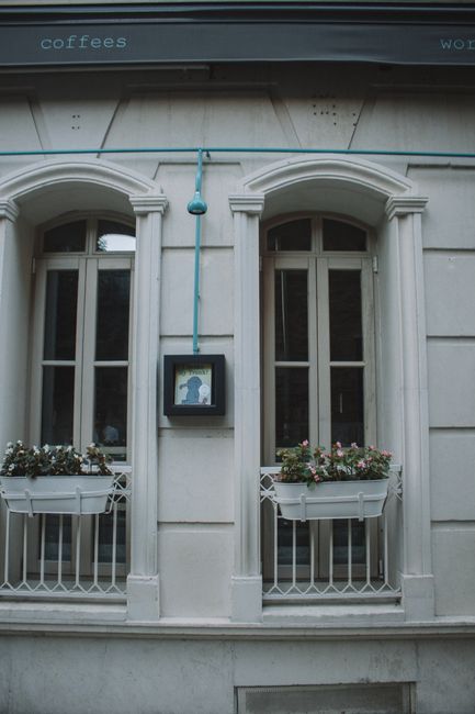 Elegant building facade with windows, flower boxes, and artistic touches, creating a cozy urban atmosphere.
