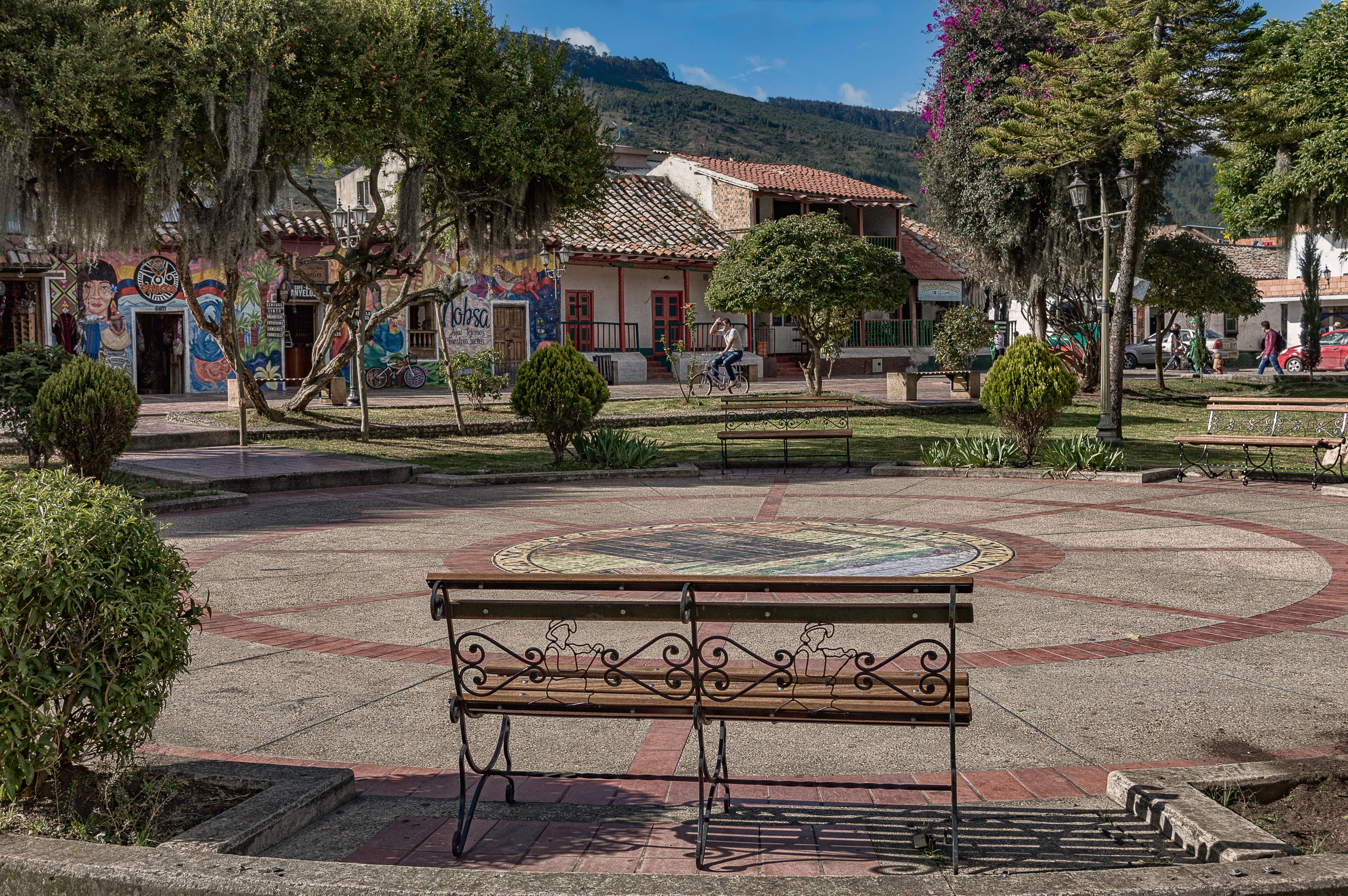 Small park with a bench and trees in a town by the mountain, Comoros