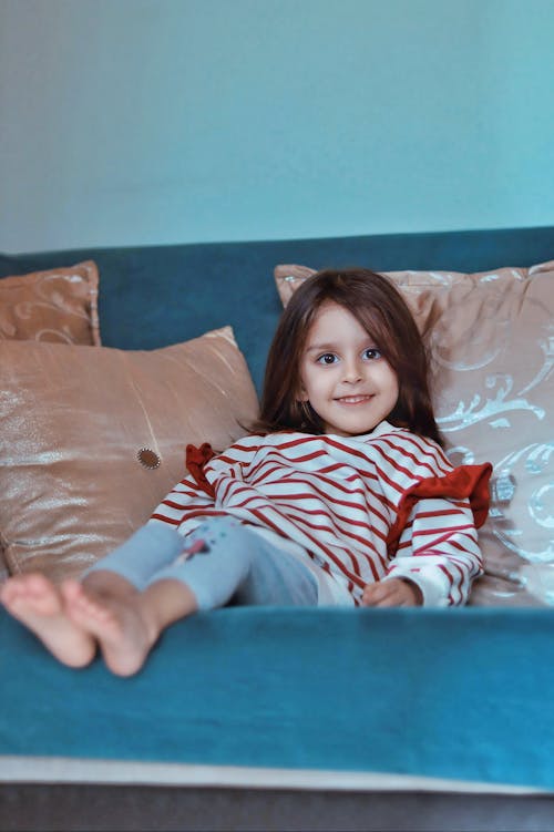 A little girl sitting on a blue couch