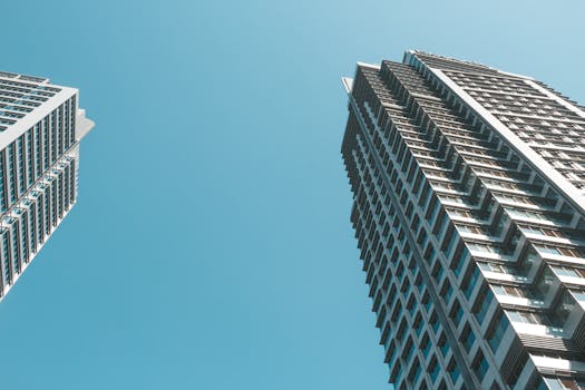 Low-angle view of contemporary skyscrapers with a clear blue sky backdrop, highlighting modern architecture.