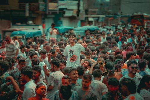 Free A colorful crowd enjoying the Holi festival on bustling city streets, capturing joyful moments. Stock Photo