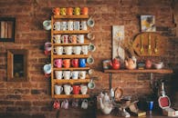 质朴的砖墙旁的架子上，陈列着一系列色彩缤纷的复古马克杯和茶壶