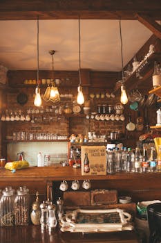 Rustic bar interior featuring wooden shelves, glassware, and warm lighting for a cozy atmosphere.