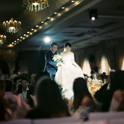 Free A bride and groom elegantly walk through their wedding reception in Hanoi, Vietnam. Stock Photo