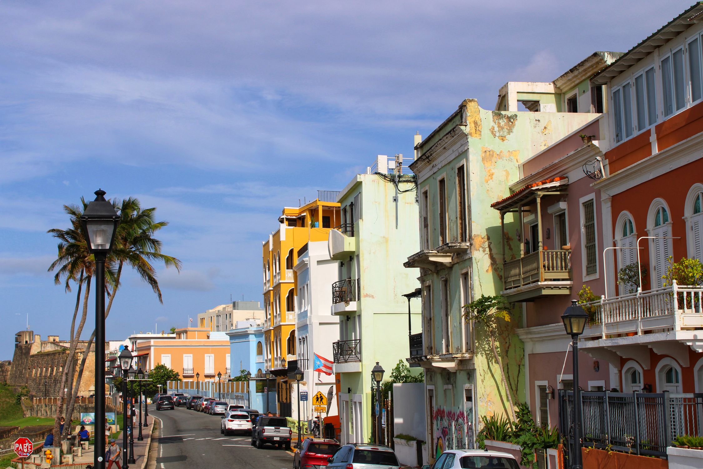 Vibrant colonial buildings line a sunny street in Old San Juan, Puerto Rico's historic district.