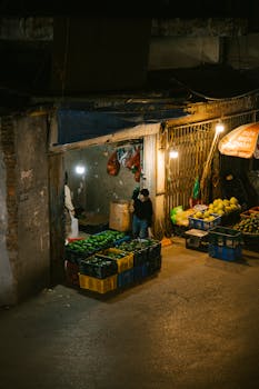 A bustling night market with fruit stalls illuminated by warm lights.