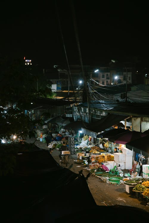 A night view of a market with fruit and vegetables