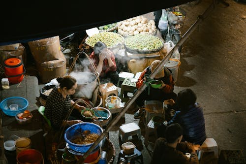 A group of people sitting around a food stand