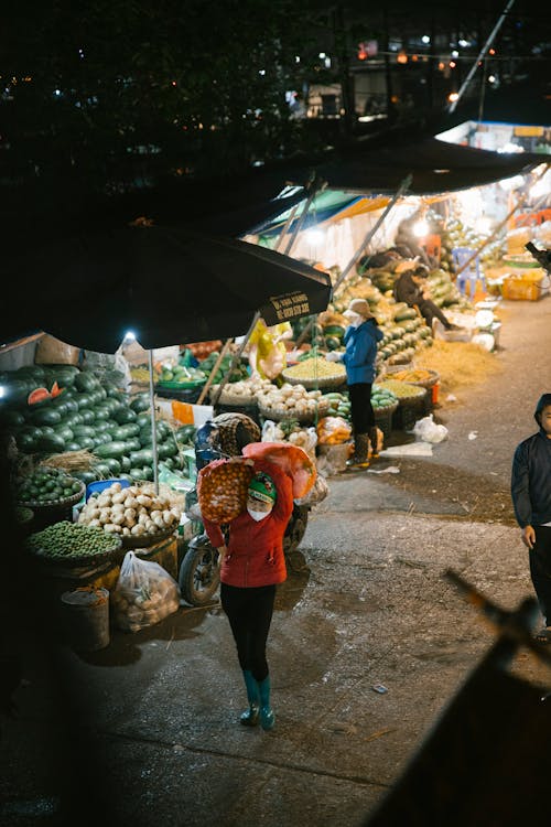 A woman carrying a bag at night in a market