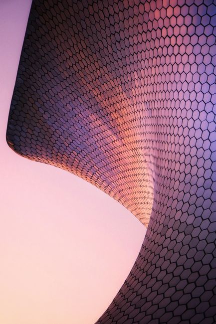 Dramatic view of Soumaya Museum's modern architecture at sunset in Mexico City.