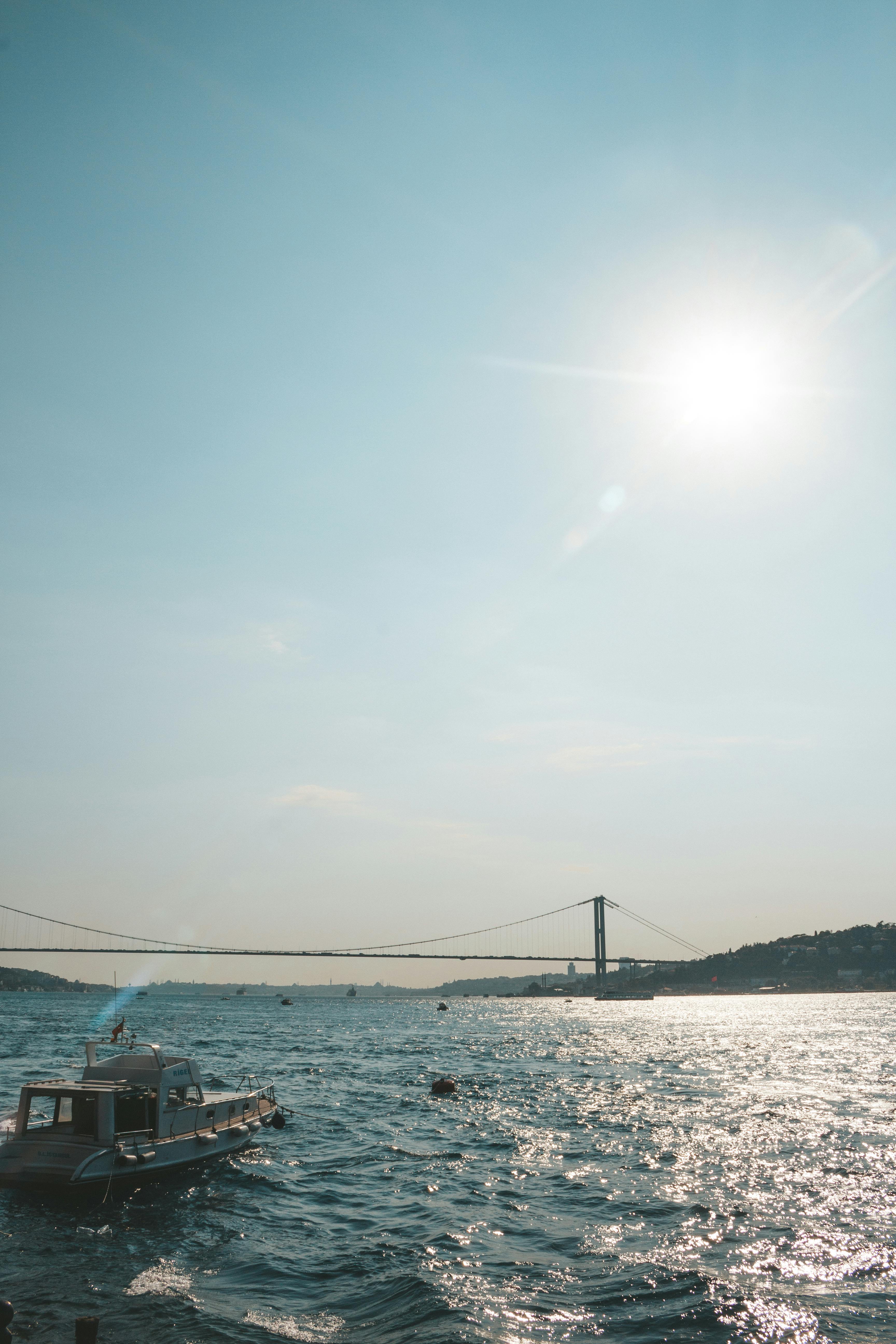 波光粼粼的蓝色水域上，一座桥横跨在明亮的阳光下