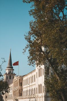 晴朗的天空下，雄伟的历史建筑矗立着塔楼和国旗