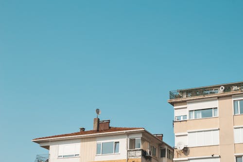 고요한 푸른 하늘 아래 건물의 로우 앵글 사진