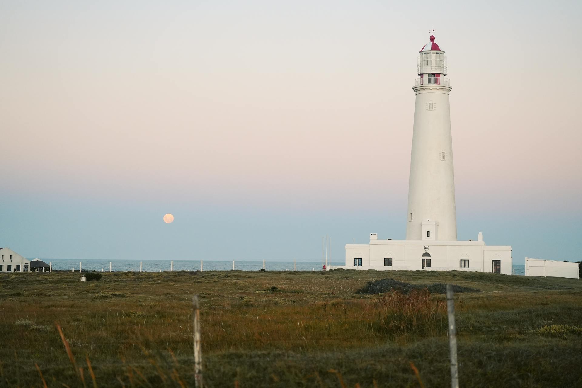 A tranquil scene of Cabo Santa Maria Lighthouse in La Paloma, Uruguay with a pastel sky at dawn.
