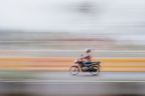 Free Dynamic shot of motorcyclist speeding down a road in Mysuru, India, capturing movement and motion blur. Stock Photo