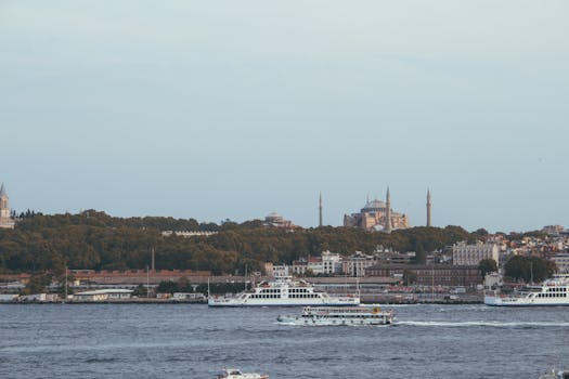 A scenic view of boats on the Bosphorus in Istanbul with the Hagia Sophia in the background.