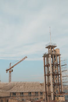 现代化城市建筑工地在蓝天下呈现出一派景观，其特色是起重机和高塔